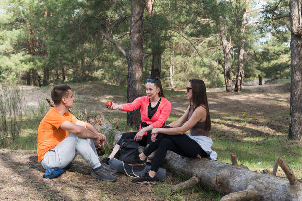 istock Three friends rest on a fallen log during a hike. 2152499339