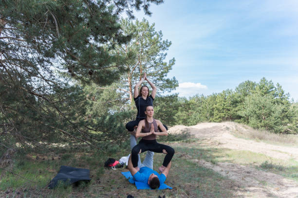 istock Thre people standing in an elaborate acro yoga pose. 2152499394