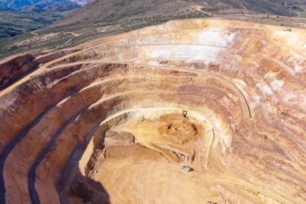 istock Open pit mine in full operation, with machinery extracting minerals. 2152501217