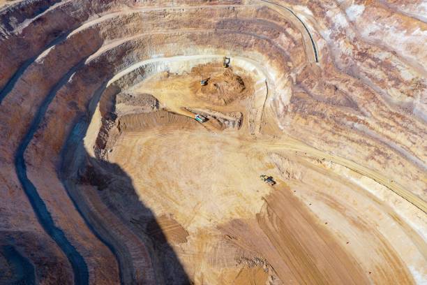 istock Open pit mine in full operation, with machinery extracting minerals. 2152501845