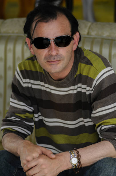Stylish Man Wearing Sunglasses Outdoors Under Sunlight, Showing Skin Care Concerns