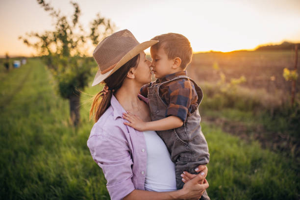 istock Woman farmer enjoys a beautiful sunset with her son 2152506643