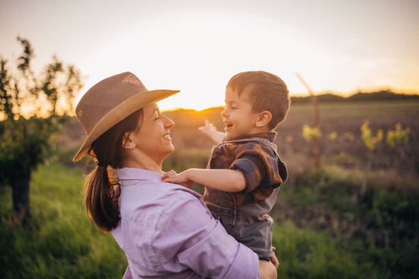 istock Woman farmer enjoys a beautiful sunset with her son 2152506823