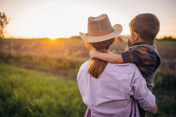 istock Woman farmer enjoys a beautiful sunset with her son 2152506900