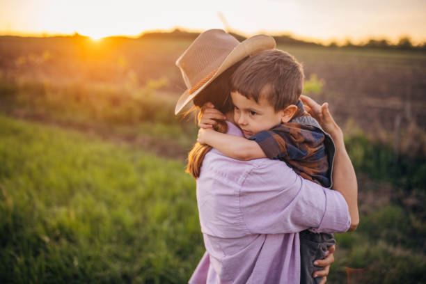 istock Woman farmer enjoys a beautiful sunset with her son 2152507424