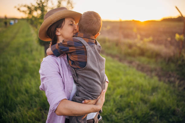istock Woman farmer enjoys a beautiful sunset with her son 2152507457