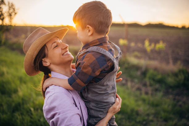 istock Woman farmer enjoys a beautiful sunset with her son 2152507496