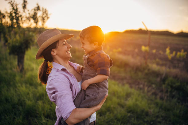 istock Woman farmer enjoys a beautiful sunset with her son 2152507548