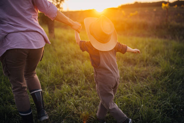 istock Woman farmer enjoys a beautiful sunset with her son 2152507842