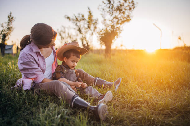istock Woman farmer enjoys a beautiful sunset with her son 2152508028