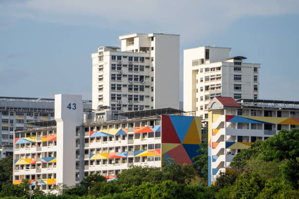 Typical colourful public housing (HDB flats) in Singapore heartland on a bright sunny day with blue sky. Architecture in yishun neighbourhood; cheerful bright pop colours; instagram worthy.