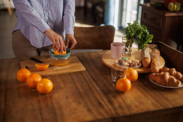 istock Woman squeezing fresh orange juice at her dining table 2152517789