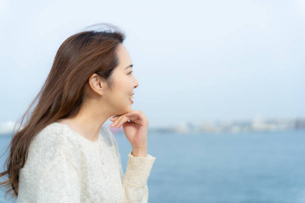 istock Long haired woman looking at the sea 2152527522