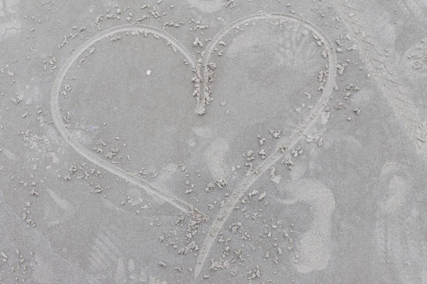 A heart painted in the fine golden sand. A backdrop for love, the beach, and vacation.