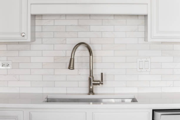 istock A brushed gold faucet detail with a subway tile marble backsplash. 2152533417
