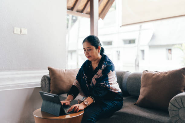 istock asian senior  woman  using tablet when Working from Anywhere in flexible working 2152533470