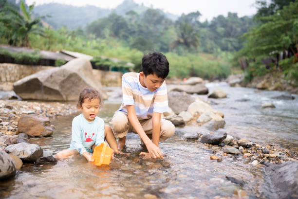 istock little boys walking on stones in stream 2152533715