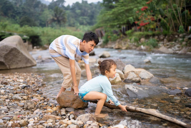 istock little boys walking on stones in stream 2152533750