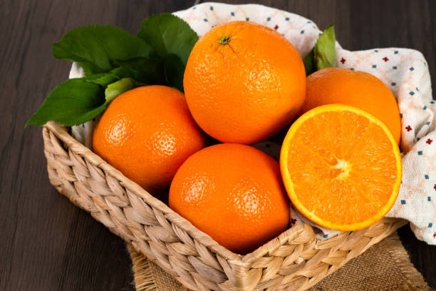 istock Orange with green leaves on the wooden table 2152546113