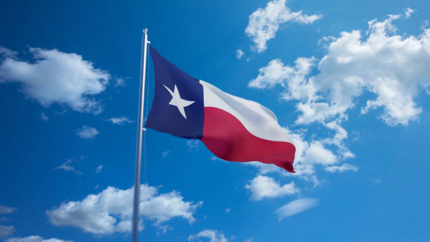 Texas flag waving on pole, bright sun in the blue summer sky on the background