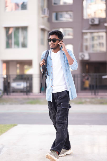 istock Young Man Talking on Phone While Walking Outdoors 2152546532
