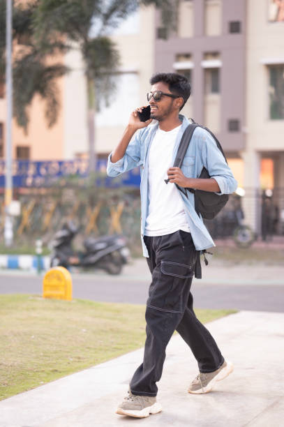 istock Young Man Talking on Phone While Walking Outdoors 2152546544