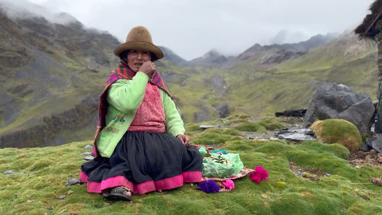 Video 4k prores HQ of a Quechua woman of the Quero ethnic group in the Andean mountains of Peru performing a ritual offering coca leaves to the gods