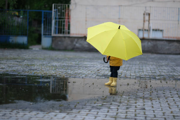 little boy having a good time in the rain
