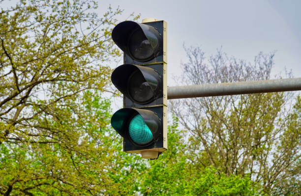 istock Green lit traffic light high up with trees in the background 2152554184