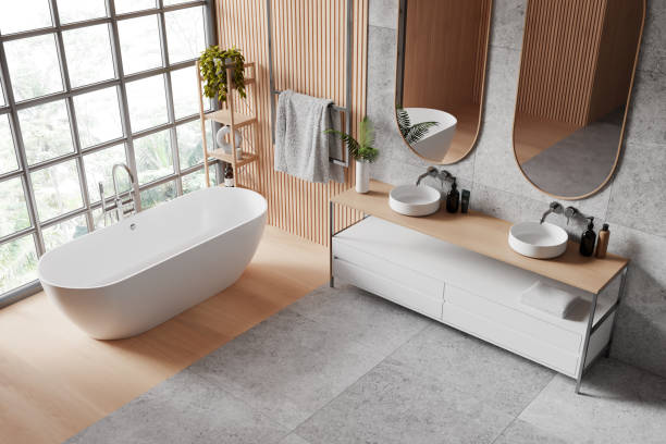 istock A spacious, modern bathroom interior with a freestanding bathtub, double sink vanity unit, mirrors, and a large window with a garden view. 3D Rendering 2152554313