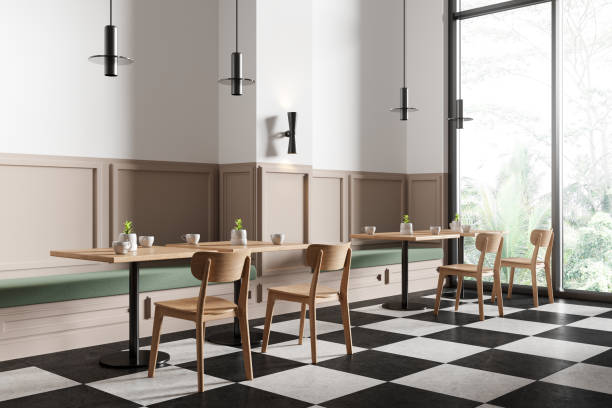 istock Stylish minimalist cafe interior with chairs and tables in row, panoramic window 2152554542