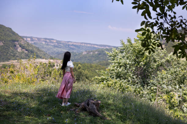 Young and beautiful woman wearing a ping skirt and a white top, wandering the alleys of  Tsarevets Fortress, Veliko Tarnovo.
