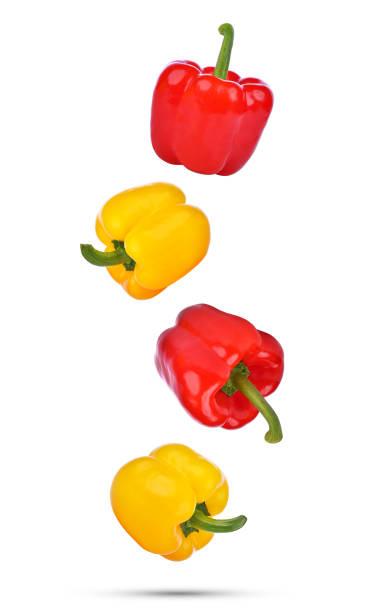 istock Whole red and yellow bell pepper falling in the air isolated on white 2152557527