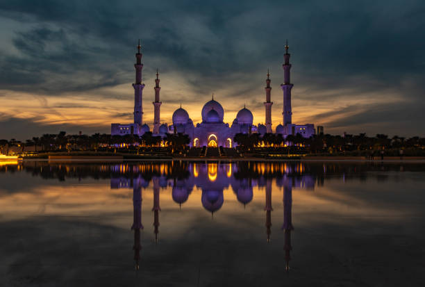 Abu Dhabi, United Arab Emirates - November 11, 2023: A picture of the Sheikh Zayed Grand Mosque reflected on the Oasis of Dignity pool, at sunset.