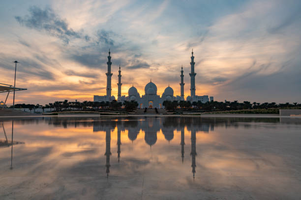 Abu Dhabi, United Arab Emirates - November 11, 2023: A picture of the Sheikh Zayed Grand Mosque reflected on the Oasis of Dignity pool, at sunset.