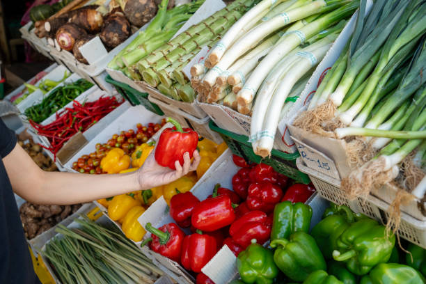 istock A customer choosing vegetables at an Asian farmer's stall. 2152565048