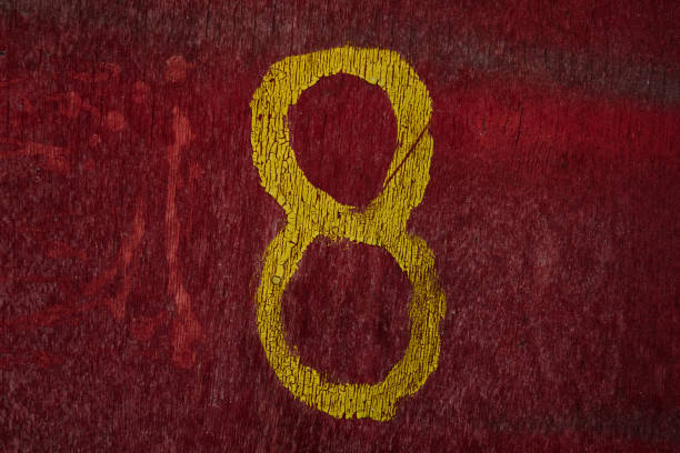 Orange number eight on blue concrete wall background. Horizontal composition.