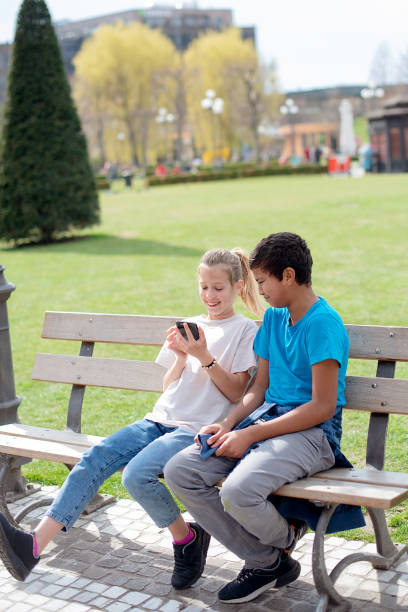 istock Friends laughing with smart phone, city park 2152567510