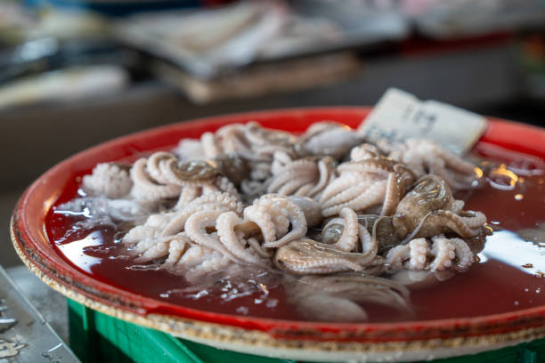 An heap of freshly caught octupus displayed on ice at an Asian fishmonger's stall.