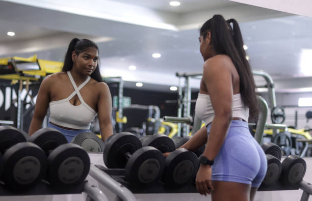 istock Young black woman looking at herself in the mirror 2152572461