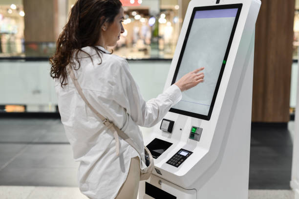 istock Female Using ATM Touch Screen To Choose Her Preferred Option 2152582509