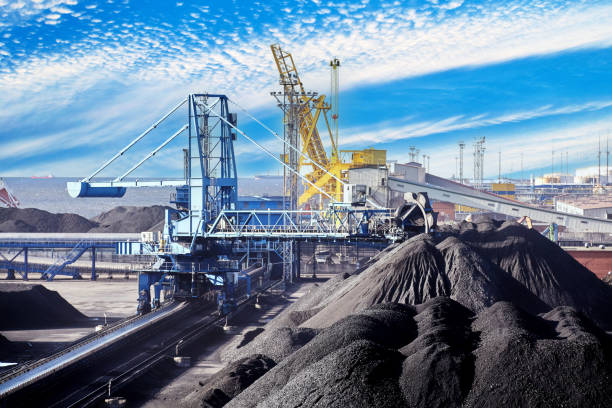 istock Coal harbor at maritime dry bulk cargo terminal, bucket wheel stacker reclaimer reloads coal onto an automatic conveyor belt. 2152585850