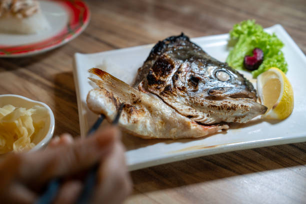 People enjoying Grilled salmon head in a Japanese restaurant.