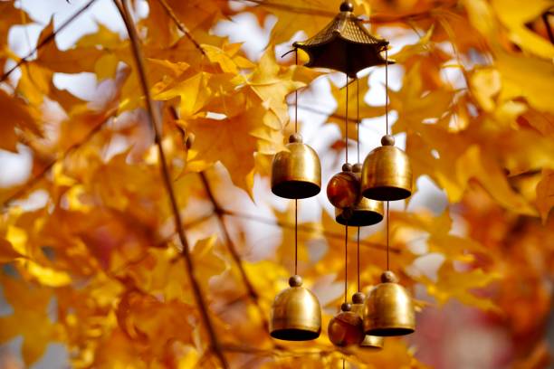 Autumn Harmony: Wind Chimes Among Golden Maple Leaves