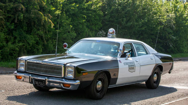 Stoke Goldington,UK - May 12th 2024: 1978 Plymouth Fury American police car driving on a British road