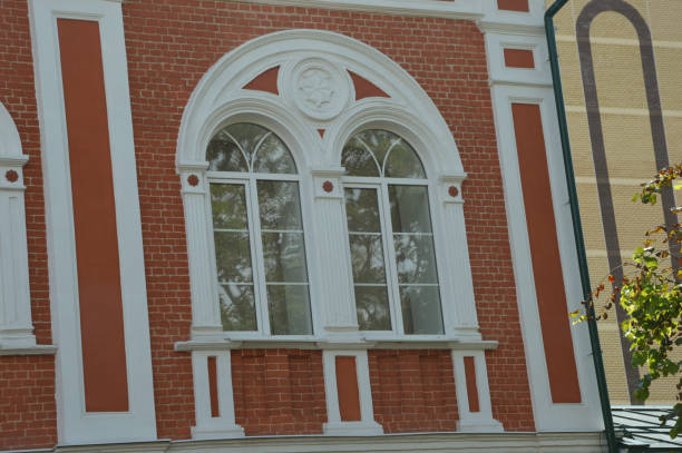 istock White arched windows against red brick walls. Building facade element. Beautiful architecture. 2152608784