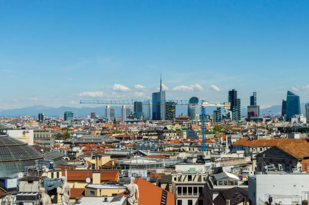 Milan, Italy - March 14, 2023: Panoramic view of Milan showcasing a blend of modern skyscrapers and traditional architecture with distant mountains