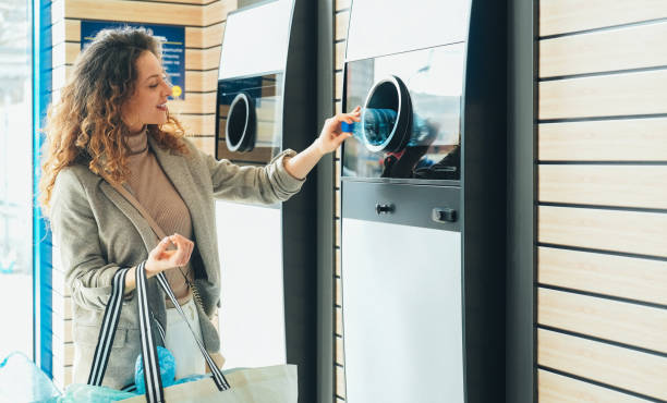 Woman recycling plastic bottle via reverse vending machine