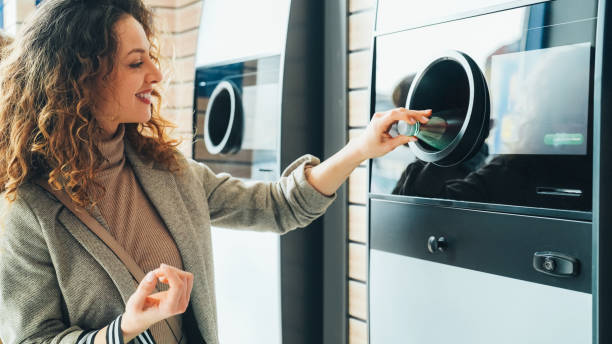 istock Woman recycling plastic bottle via reverse vending machine 2152627897