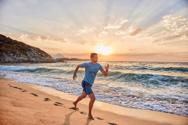 istock Active man running on the beach at sunset 2152630609